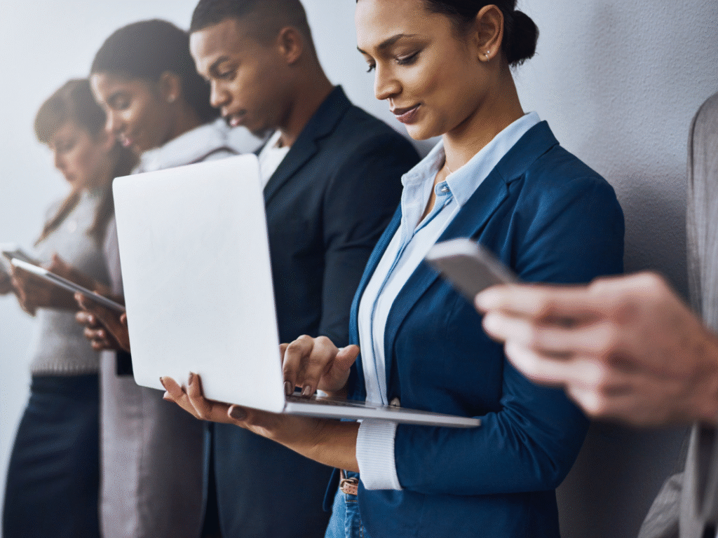 Group of professionals using digital devices, representing specialist technology talent and candidate sourcing.